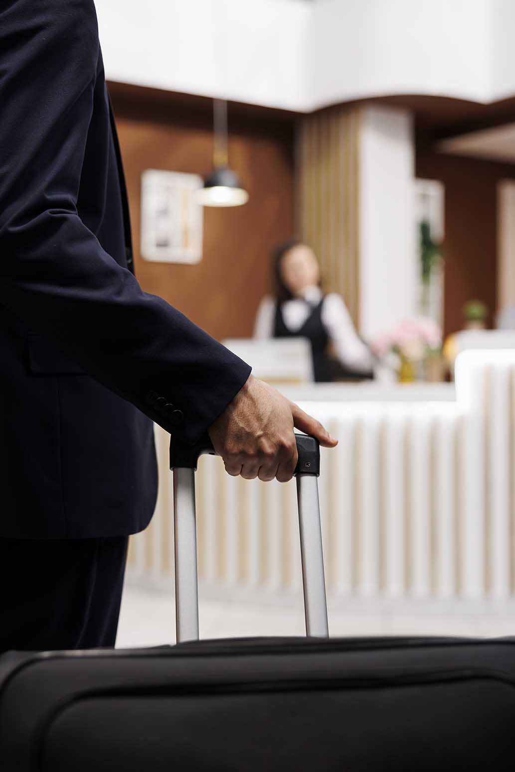 Hotel guest enter reception with luggage